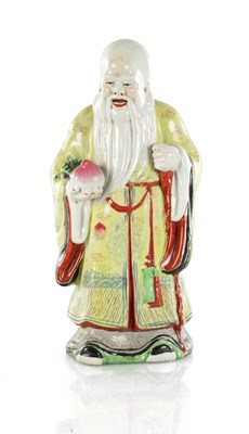 Lot 659 - AN EARLY 20TH CENTURY CHINESE PORCELAIN FIGURE OF AN ELDER HOLDING FRUIT