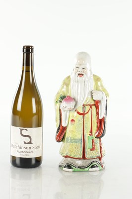 Lot 659 - AN EARLY 20TH CENTURY CHINESE PORCELAIN FIGURE OF AN ELDER HOLDING FRUIT