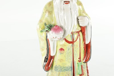 Lot 659 - AN EARLY 20TH CENTURY CHINESE PORCELAIN FIGURE OF AN ELDER HOLDING FRUIT