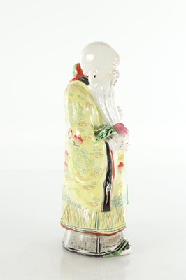 Lot 659 - AN EARLY 20TH CENTURY CHINESE PORCELAIN FIGURE OF AN ELDER HOLDING FRUIT
