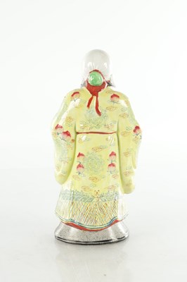 Lot 659 - AN EARLY 20TH CENTURY CHINESE PORCELAIN FIGURE OF AN ELDER HOLDING FRUIT