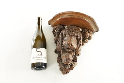 Lot 939 - A 19TH CENTURY BLACK FOREST CARVED LINDEN WOOD HANGING BRACKET FORMED AS A DOGS HEAD