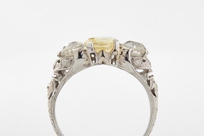 Lot 240 - A PLATINUM YELLOW SAPPHIRE AND DIAMOND THREE-STONE RING