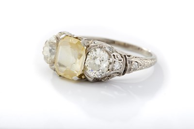 Lot 240 - A PLATINUM YELLOW SAPPHIRE AND DIAMOND THREE-STONE RING