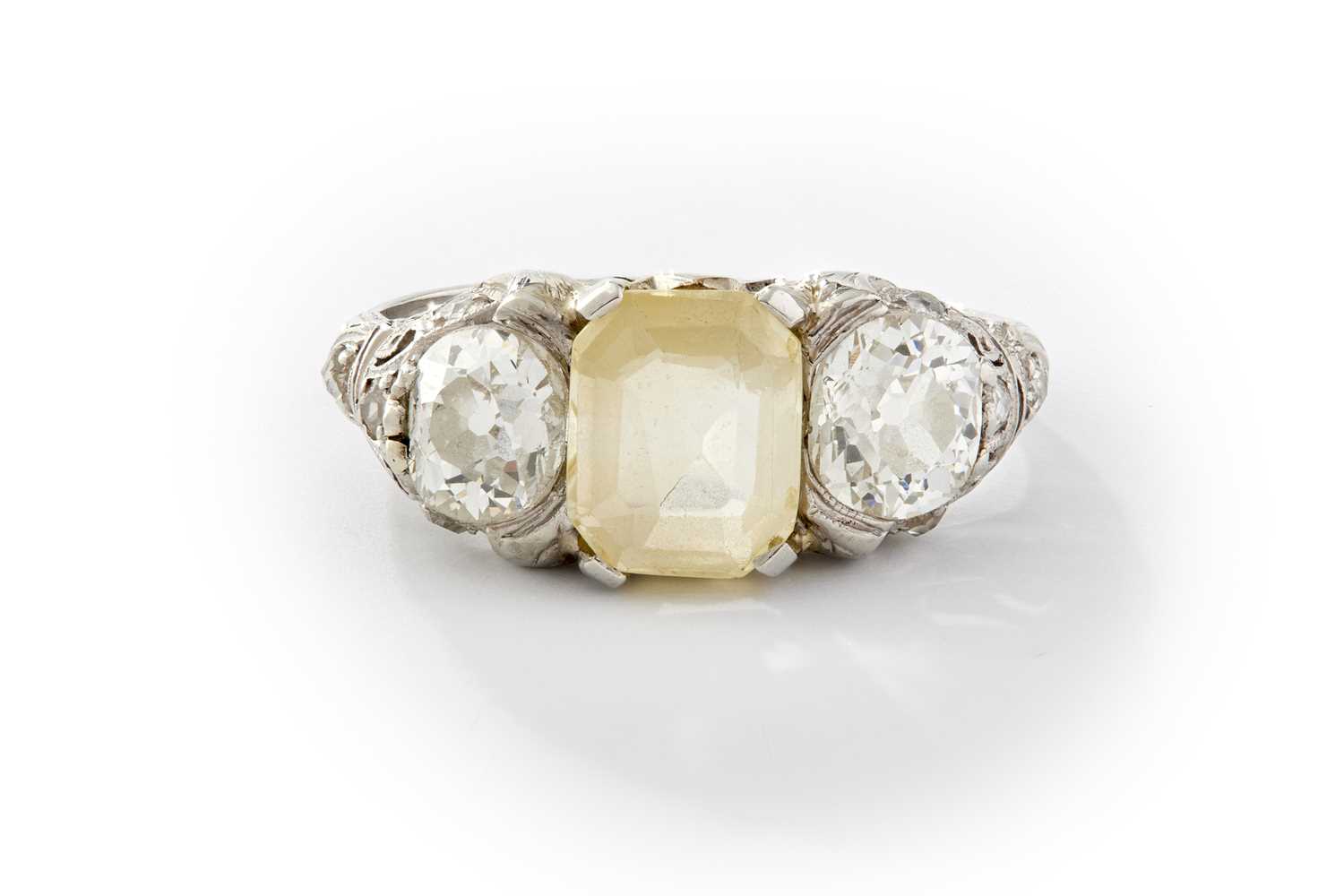 Lot 240 - A PLATINUM YELLOW SAPPHIRE AND DIAMOND THREE-STONE RING