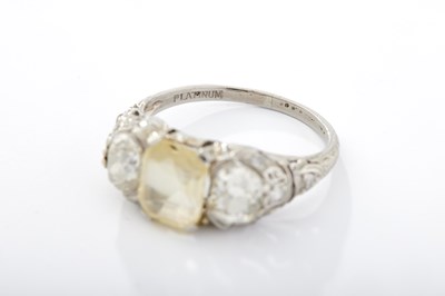 Lot 240 - A PLATINUM YELLOW SAPPHIRE AND DIAMOND THREE-STONE RING