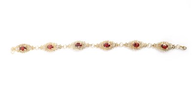 Lot 241 - A LADIES' VINTAGE 9CT GOLD AND GARNET FILIGREE BRACELET