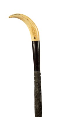 Lot AN AFRICAN CARVED HARDWOOD STICK WITH BOARS TUSK HANDLE