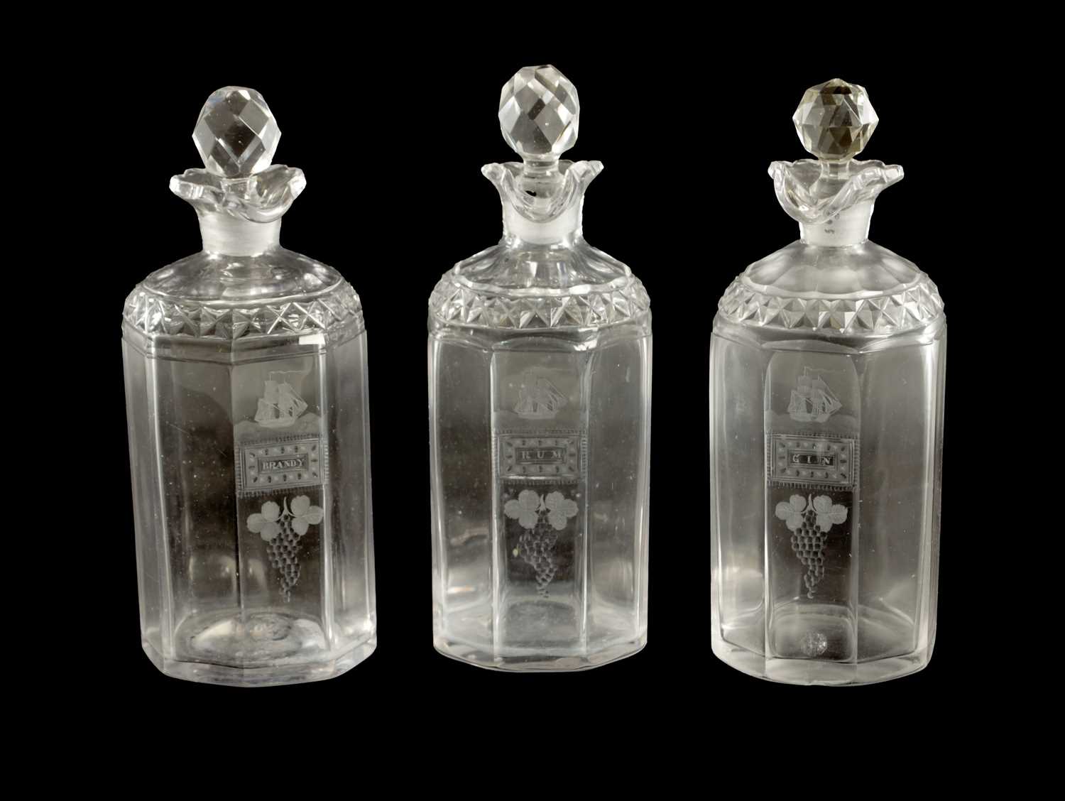 Lot 373 - A SET OF THREE GEORGIAN CUT GLASS DECANTERS