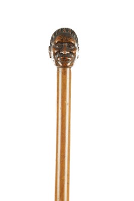 Lot 813 - A 20TH CENTURY CARVED WOOD WALKING STICK WITH MAORI HEAD HANDLE