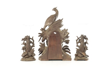 Lot 977 - A 19TH CENTURY BLACK FOREST CARVED THREE PIECE CLOCK GARNITURE