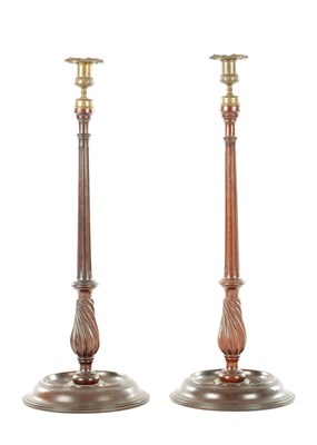 Lot A LARGE PAIR OF 19TH CENTURY MAHOGANY AND BRASS CANDLESTICKS
