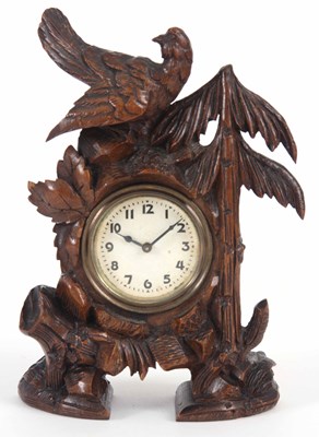 Lot 143 - A CARVED BLACK FOREST MANTLE CLOCK with bird...