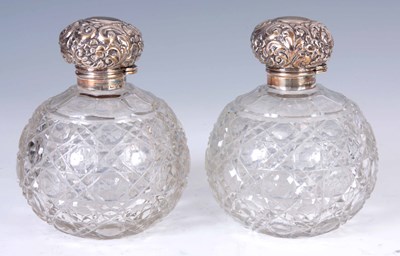 Lot 215 - A PAIR OF SILVER TOPPED PERFUME BOTTLES having...