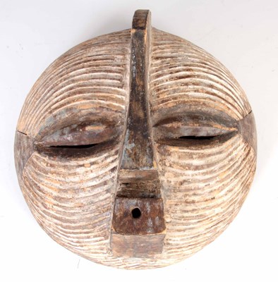 Lot 427 - AN AFRICAN CARVED WOOD LUBA MASK of circular...