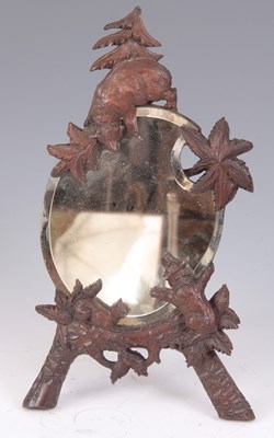 Lot 510 - A LATE 19TH CENTURY BLACK FOREST EASEL MIRROR...