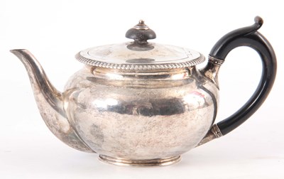 Lot 221 - A GEORGE III SILVER TEAPOT with ebonised...