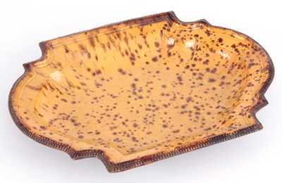 Lot 73 - AN 18TH CENTURY POTTERY DISH having treacle...